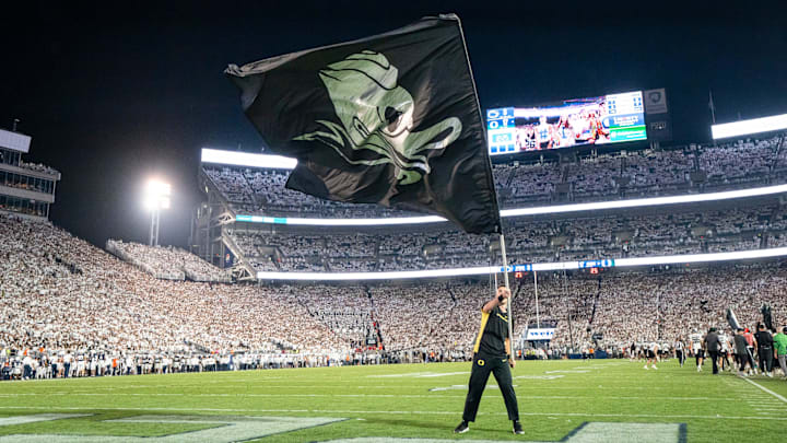 An Oregon cheerleader waves a Duck flag at Penn State An Oregon cheerleader waves a Duck flag at Penn State