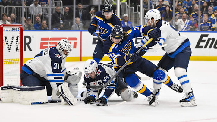 Apr 24, 2025; St. Louis, Missouri, USA; Winnipeg Jets goaltender Connor Hellebuyck (37) defenseman Josh Morrissey (44) and center Cole Perfetti (91) defend the net against St. Louis Blues center Oskar Sundqvist (70) during the second period in game three of the first round of the 2025 Stanley Cup Playoffs at Enterprise Center. Mandatory Credit: Jeff Curry-Imagn Images