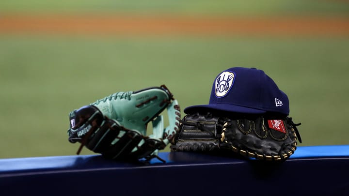May 7, 2021; Miami, Florida, USA; Baseball gloves and a Milwaukee Brewers hat rest over a handrail in the Brewers    dugout prior a game against the Miami Marlins at loanDepot park. Mandatory Credit: Sam Navarro-USA TODAY Sports
