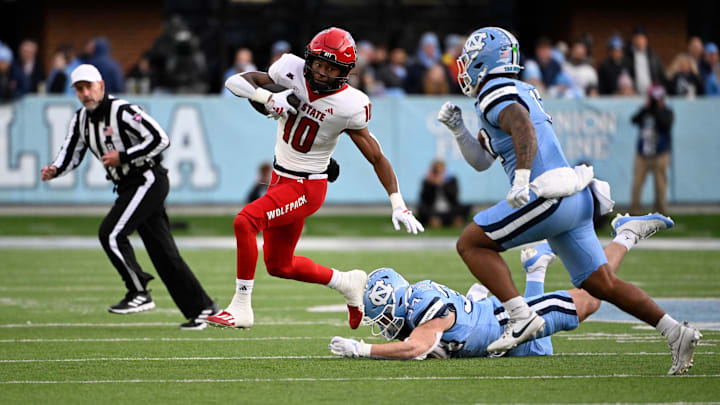 North Carolina State Wolfpack wide receiver Kevin Concepcion (10) with the ball as North Carolina Tar Heels linebacker Caleb LaVallee (34) and linebacker Amare Campbell (17) defend in the first quarter at Kenan Memorial Stadium.
