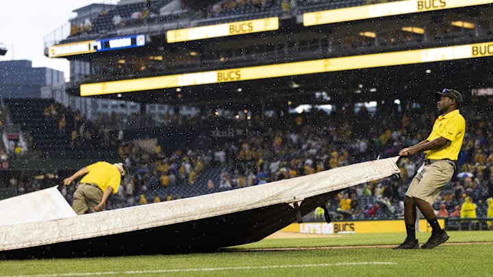 Jul 1, 2023; Pittsburgh, Pennsylvania, USA; The Pittsburgh Pirates grounds crew pulls the tarp onto the field  during a rain delay in the ninth inning against the Milwaukee Brewers at PNC Park. Mandatory Credit: Scott Galvin-Imagn Images