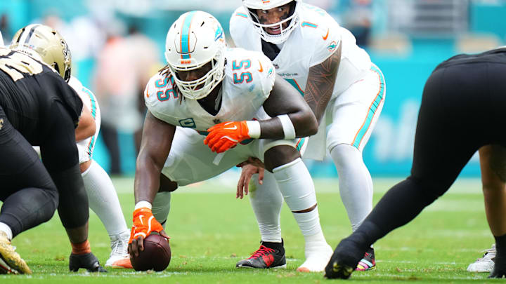 Nov 30, 2025; Miami Gardens, Florida, USA; Miami Dolphins quarterback Tua Tagovailoa (1) under center Aaron Brewer (55) against the New Orleans Saints during the first half at Hard Rock Stadium. Mandatory Credit: Rich Storry-Imagn Images