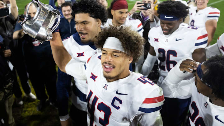 Nov 28, 2025; Tempe, Arizona, USA; Arizona Wildcats defensive back Dalton Johnson (43) celebrates with the Territorial Cup trophy after defeating the Arizona State Sun Devils in the 99th Territorial Cup at Mountain America Stadium. Mandatory Credit: Mark J. Rebilas-Imagn Images