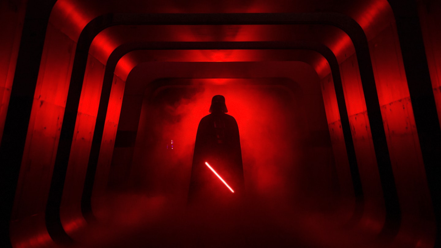 A promotional image or still from the Darth Vader hallway scene in Rogue One, showing Vader's silhouette with his red lightsaber against fleeing Rebel soldiers.