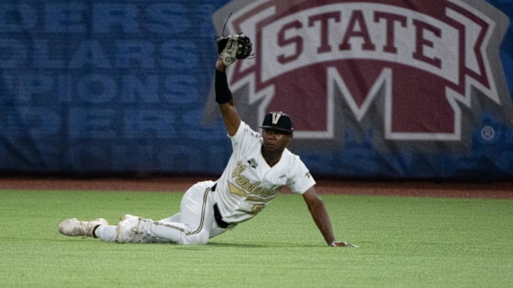 May 24, 2022; Hoover, AL, USA; Vanderbilt centerfielder Enrique Bradfield Jr. shows he had made a diving catch on a line drive. Vanderbilt faced Ole Miss in game 3 of the SEC Tournament at the Hoover Met. Ncaa Baseball Sec Baseball Tournament Vanderbilt Commodores Vs Ole Miss Rebels May 24, 2022; Hoover, AL, USA; Vanderbilt centerfielder Enrique Bradfield Jr. shows he had made a diving catch on a line drive. Vanderbilt faced Ole Miss in game 3 of the SEC Tournament at the Hoover Met. Ncaa Baseball Sec Baseball Tournament Vanderbilt Commodores Vs Ole Miss Rebels
