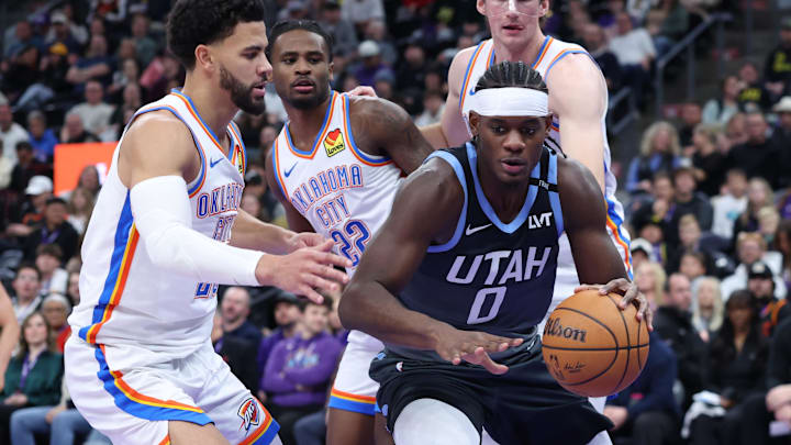 Dec 7, 2025; Salt Lake City, Utah, USA; Utah Jazz forward Taylor Hendricks (0) goes to the basket against Oklahoma City Thunder guard Ajay Mitchell (left), guard Cason Wallace (22) and center Branden Carlson (back) during the second half at Delta Center. Mandatory Credit: Rob Gray-Imagn Images