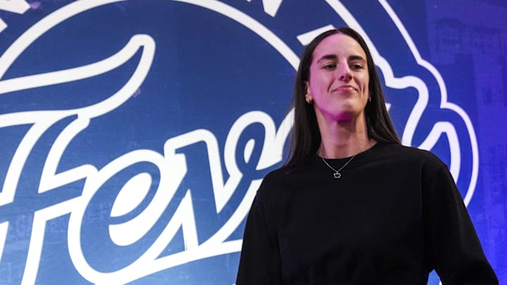 Indiana Fever guard Caitlin Clark (22) walks past the photo backdrop before a game between the Indiana Fever and the Connecticut Sun at Gainbridge Fieldhouse.