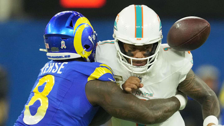 Nov 11, 2024; Inglewood, California, USA; Los Angeles Rams linebacker Jared Verse (8) forces a fumble by Miami Dolphins quarterback Tua Tagovailoa (1) in the first half at SoFi Stadium. Mandatory Credit: Kirby Lee-Imagn Images