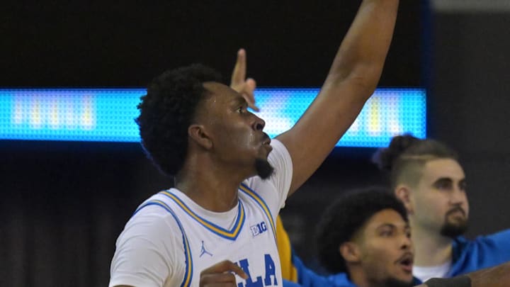 Feb 3, 2026; Los Angeles, California, USA;  UCLA Bruins forward Xavier Booker (1) shoots a three-point basket over Rutgers Scarlet Knights center Emmanuel Ogbole (21) in the second half at Pauley Pavilion presented by Wescom Financial. Mandatory Credit: Jayne Kamin-Oncea-Imagn Images