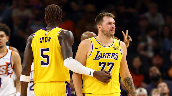 Oct 14, 2025; Phoenix, Arizona, USA; Los Angeles Lakers guard Luka Doncic (77) with center Deandre Ayton (5) against the Phoenix Suns during an NBA preseason game at Mortgage Matchup Center. Mandatory Credit: Mark J. Rebilas-Imagn Images Oct 14, 2025; Phoenix, Arizona, USA; Los Angeles Lakers guard Luka Doncic (77) with center Deandre Ayton (5) against the Phoenix Suns during an NBA preseason game at Mortgage Matchup Center. Mandatory Credit: Mark J. Rebilas-Imagn Images