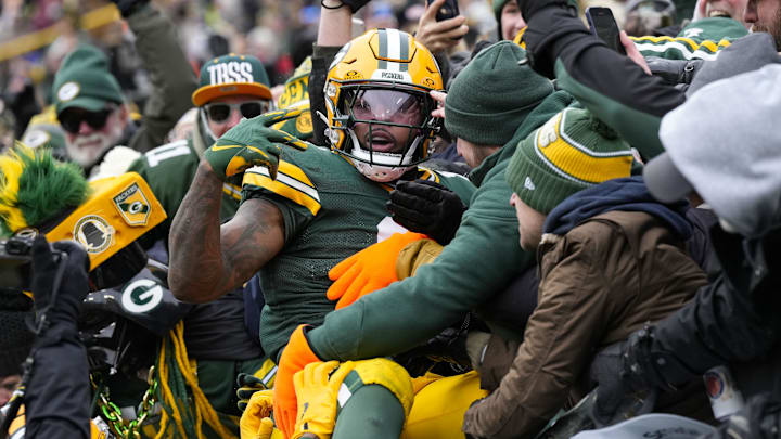Green Bay Packers running back Josh Jacobs celebrates with the fans after scoring against the Bears.
