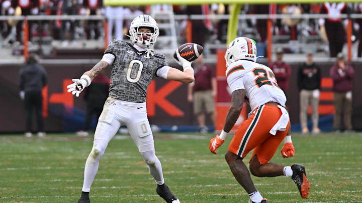 Nov 22, 2025; Blacksburg, Va.; Virginia Tech wide receiver Ayden Greene (0) throws a pass as Miami defensive back Dylan Day (23) pursues.
