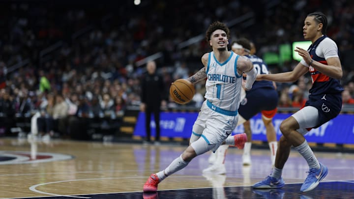 Dec 26, 2024; Washington, District of Columbia, USA; Charlotte Hornets guard LaMelo Ball (1) drives to the basket as Washington Wizards forward Kyshawn George (18) defends in the first quarter at Capital One Arena. Mandatory Credit: Geoff Burke-Imagn Images