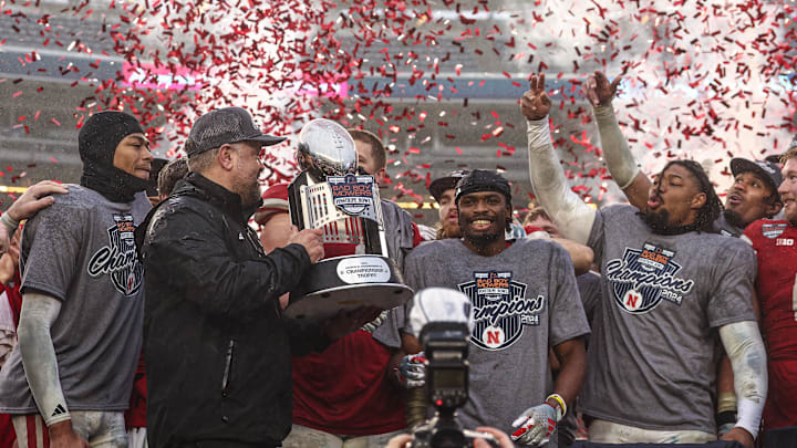 Dec 28, 2024; Bronx, NY, USA; Nebraska Cornhuskers head coach Matt Rhule holds the championship trophy as Cornhuskers players celebrate after the game against the Boston College Eagles at Yankee Stadium. Mandatory Credit: Vincent Carchietta-Imagn Images