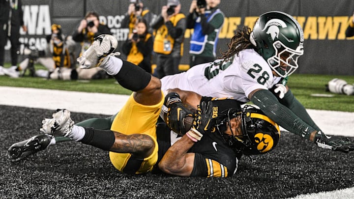 Nov 22, 2025; Iowa City, Iowa, USA; Iowa Hawkeyes wide receiver Jacob Gill (5) catches the game tying touchdown as Michigan State Spartans defensive back Dontavius Nash (28) defends during the fourth quarter at Kinnick Stadium. Mandatory Credit: Jeffrey Becker-Imagn Images