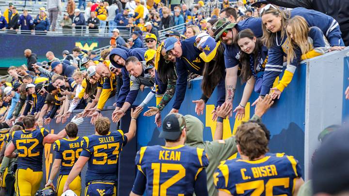 Nov 8, 2025; Morgantown, West Virginia, USA; West Virginia Mountaineers players celebrate with fans after defeating the Colorado Buffaloes at Milan Puskar Stadium. Mandatory Credit: Ben Queen-Imagn Images Nov 8, 2025; Morgantown, West Virginia, USA; West Virginia Mountaineers players celebrate with fans after defeating the Colorado Buffaloes at Milan Puskar Stadium. Mandatory Credit: Ben Queen-Imagn Images