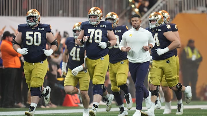 Jan 20, 2025; Atlanta, GA, USA; Notre Dame Fighting Irish head coach Marcus Freeman and his players run to the field before playing against the Ohio State Buckeyes in the CFP National Championship college football game at Mercedes-Benz Stadium. Mandatory Credit: Kirby Lee-Imagn Images