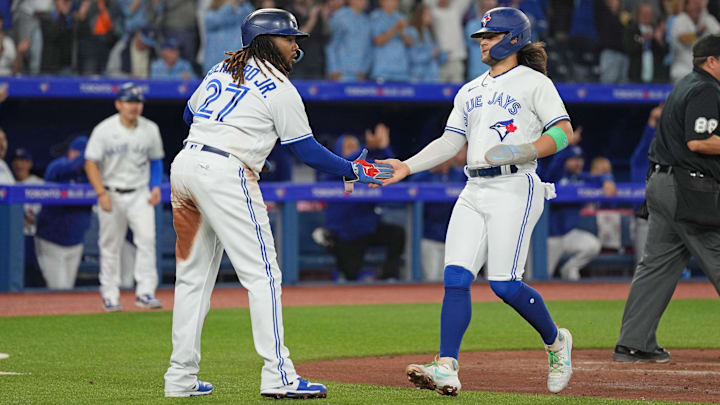 Sep 29, 2023; Toronto, Ontario, CAN; Toronto Blue Jays first baseman Vladimir Guerrero Jr. (27) and shortstop Bo Bichette (11) both celebrate scoring runs against the Tampa Bay Rays during the third inning at Rogers Centre.