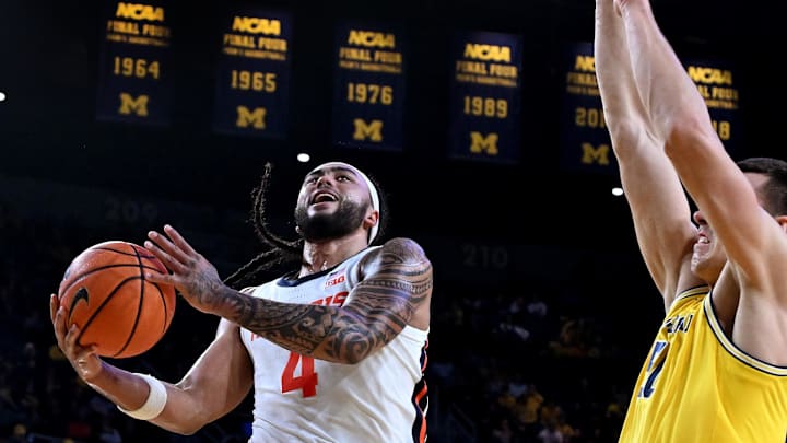 Mar 2, 2025; Ann Arbor, Michigan, USA;  Illinois Fighting Illini guard Kylan Boswell (4) drives to the basket past Michigan Wolverines center Vladislav Goldin (50) in the second half at Crisler Center. Mandatory Credit: Lon Horwedel-Imagn Images