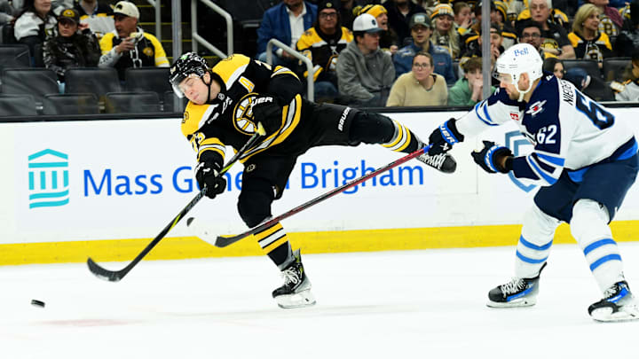 Jan 30, 2025; Boston, Massachusetts, USA; Boston Bruins defenseman Charlie McAvoy (73) shoots the puck while Winnipeg Jets right wing Nino Niederreiter (62) defends during the third period at TD Garden. Mandatory Credit: Bob DeChiara-Imagn Images