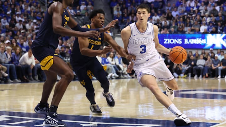 Mar 1, 2025; Provo, Utah, USA; Brigham Young Cougars guard Egor Demin (3) drives to the basket against West Virginia Mountaineers guard Joseph Yesufu (1) and center Eduardo Andre (0) during the first half at Marriott Center.