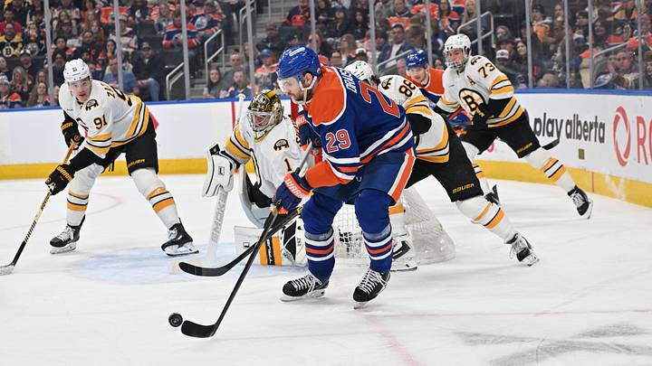 Dec 31, 2025; Edmonton, Alberta, CAN; Edmonton Oilers center Leon Draisaitl (29) plays the puck in front of Boston Bruins goalie Jeremy Swayman (1) during the third period at Rogers Place. Mandatory Credit: Walter Tychnowicz-Imagn Images
