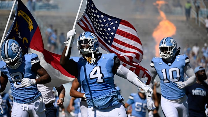 Oct 12, 2024; Chapel Hill, North Carolina, USA; North Carolina Tar Heels defensive lineman Travis Shaw (4) runs on to the field with the american flag before the game at Kenan Memorial Stadium. Mandatory Credit: Bob Donnan-Imagn Images