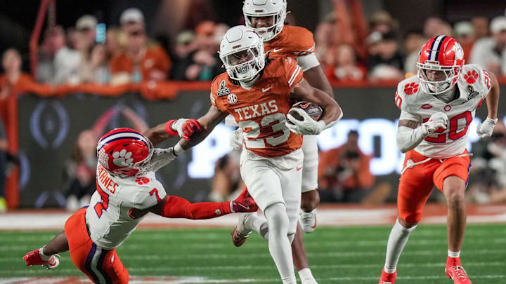 Texas running back Jaydon Blue (23) stiff-arms Clemson safety Khalil Barnes (7).