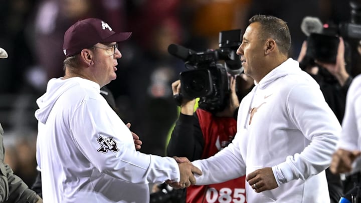 Nov 30, 2024; College Station, Texas, USA; Texas A&M Aggies head coach Mike Elko, left, shakes hands with Texas Longhorns head coach Steve Sarkisian after the game. The Longhorns defeated the Aggies 17-7. at Kyle Field. Mandatory Credit: Maria Lysaker-Imagn Images 