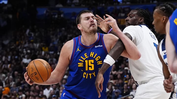 Mar 1, 2026; Denver, Colorado, USA; Minnesota Timberwolves center Naz Reid (11) fouls Denver Nuggets center Nikola Jokic (15) in the second half at Ball Arena. Mandatory Credit: Ron Chenoy-Imagn Images