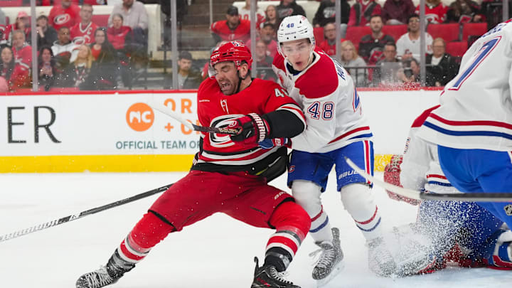Mar 29, 2026; Raleigh, North Carolina, USA;  Montreal Canadiens defenseman Lane Hutson (48) and Carolina Hurricanes left wing Jordan Martinook (48) battle in front of the net ]during the first period at Lenovo Center. Mandatory Credit: James Guillory-Imagn Images