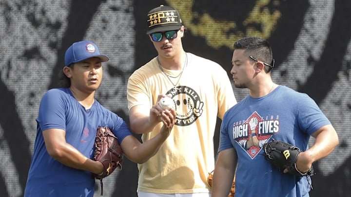 Chicago Cubs pitcher Shota Imanaga (left) and Pittsburgh Pirates pitcher Paul Skenes (middle) discuss pitching grips as Edwin Stanberry (right) interprets before the Pirates host the Cubs at PNC Park.