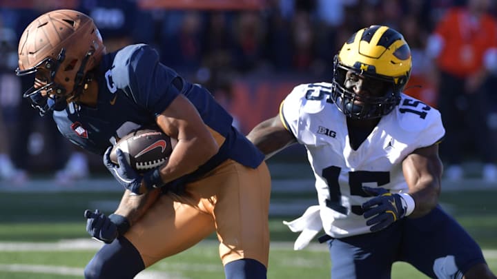 Oct 19, 2024; Champaign, Illinois, USA; Illinois Fighting Illini wide receiver Pat Bryant (13) makes a short catch and run against Michigan Wolverines linebacker Ernest Hausmann (15) during the first half at Memorial Stadium. Mandatory Credit: Ron Johnson-Imagn Images Oct 19, 2024; Champaign, Illinois, USA; Illinois Fighting Illini wide receiver Pat Bryant (13) makes a short catch and run against Michigan Wolverines linebacker Ernest Hausmann (15) during the first half at Memorial Stadium. Mandatory Credit: Ron Johnson-Imagn Images