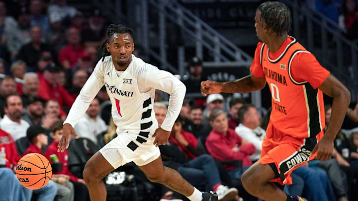 Cincinnati Bearcats guard Day Day Thomas (1) dribbles the ball down the court in the first half of a NCAA men’s basketball game between the Cincinnati Bearcats and Oklahoma State Cowboys, Saturday, Feb. 28, 2026, at Fifth Third Arena in Cincinnati. Cincinnati Bearcats guard Day Day Thomas (1) dribbles the ball down the court in the first half of a NCAA men’s basketball game between the Cincinnati Bearcats and Oklahoma State Cowboys, Saturday, Feb. 28, 2026, at Fifth Third Arena in Cincinnati.
