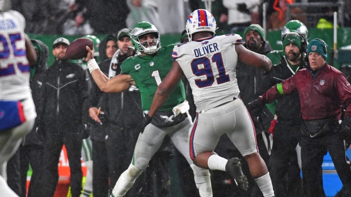 Nov 26, 2023; Philadelphia, PA; Philadelphia Eagles quarterback Jalen Hurts (1) throws touchdown pass in fourth quarter under pressure form Buffalo Bills defensive tackle Ed Oliver (91) at Lincoln Financial Field