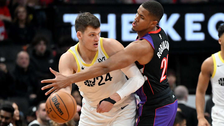 Mar 7, 2025; Toronto, Ontario, CAN;  Utah Jazz center Walker Kessler (24) looks to make a pass as Toronto Raptors center Orlando Robinson (21) defends in the first half at Scotiabank Arena. Mandatory Credit: Dan Hamilton-Imagn Images