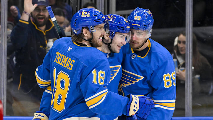 Apr 5, 2025; St. Louis, Missouri, USA;  St. Louis Blues left wing Pavel Buchnevich (89) celebrates with right wing Jimmy Snuggerud (21) and center Robert Thomas (18) after scoring against the Colorado Avalanche during the second period at Enterprise Center. Mandatory Credit: Jeff Curry-Imagn Images