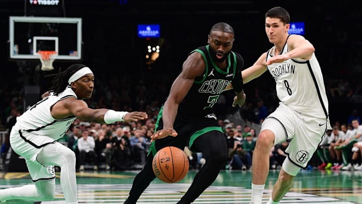 Nov 21, 2025; Boston, Massachusetts, USA; Boston Celtics guard Jaylen Brown (7) controls the ball between Brooklyn Nets guard Terance Mann (14) and guard Egor Demin (8) during the second half at TD Garden. Mandatory Credit: Bob DeChiara-Imagn Images