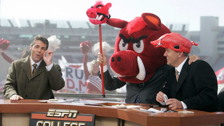 Lee Corso picks the Razorbacks to win the Arkansas/Tennessee game as Chris Fowler, left, and Kirk Herbstreit, right, end the show. ESPN College GameDay is a weekly television program that airs during the college football season. The hosts are Kirk Herbstreit, Lee Corso, and Chris Fowler. The production was in Fayetteville, Arkansas Nov. 12 for the Arkansas/Tennessee game.