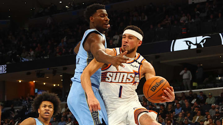 Feb 25, 2025; Memphis, Tennessee, USA; Phoenix Suns guard Devin Booker (1) passes the ball as Memphis Grizzlies forward Jaren Jackson Jr. (13) defends during the third quarter at FedExForum. Mandatory Credit: Petre Thomas-Imagn Images