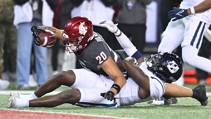 Nov 9, 2024; Pullman, Washington, USA; Washington State Cougars running back Leo Pulalasi (20) stretches for the goal line against Utah State Aggies safety Ike Larsen (6) in the second half at Gesa Field at Martin Stadium. Mandatory Credit: James Snook-Imagn Images
