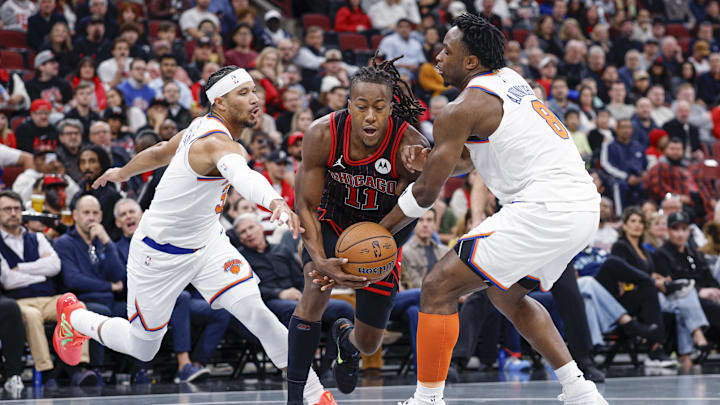 Oct 31, 2025; Chicago, Illinois, USA; Chicago Bulls guard Ayo Dosunmu (11) drives to the basket between New York Knicks forward OG Anunoby (8) and guard Josh Hart (3) during the first half at United Center. Mandatory Credit: Kamil Krzaczynski-Imagn Images