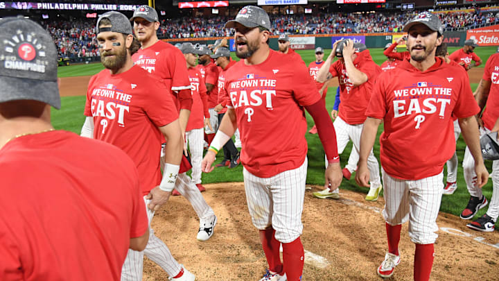 Sep 23, 2024; Philadelphia, Pennsylvania, USA; Philadelphia Phillies first baseman Bryce Harper (3), designated hitter Kyle Schwarber (12) and catcher Garrett Stubbs (21) celebrate winning National League East Division with a win against the Chicago Cubs at Citizens Bank Park