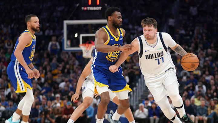 Dallas Mavericks guard Luka Doncic (77) dribbles past Golden State Warriors forward Andrew Wiggins (22) in the second quarter at the Chase Center. Mandatory Credit: Cary Edmondson-Imagn Images