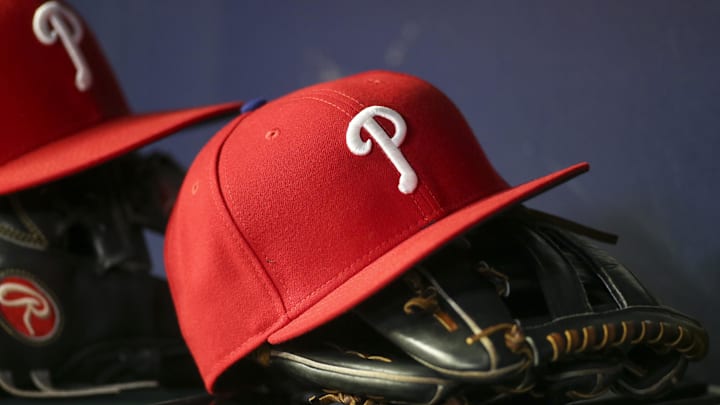 Detailed view of a Philadelphia Phillies hat and glove in the dugout