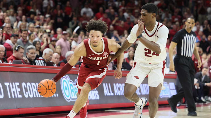 Feb 8, 2025; Fayetteville, Arkansas, USA; Alabama Crimson Tide guard mark Sears (1) drives against Arkansas Razorbacks forward Billy Richmond III (24) during the second half at Bud Walton Arena. Alabama won 85-81. Mandatory Credit: Nelson Chenault-Imagn Images