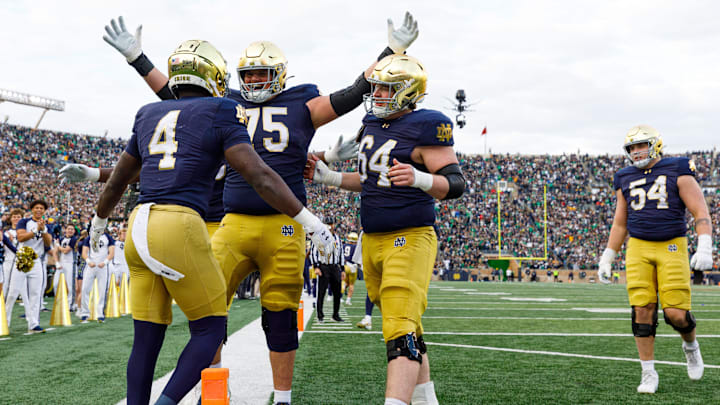 Notre Dame offensive lineman Sullivan Absher (75) and offensive lineman Joe Otting (64) celebrate after a touchdown scored by running back Jeremiyah Love (4) in the first half of a NCAA football game against Syracuse at Notre Dame Stadium on Saturday, Nov. 22, 2025, in South Bend. Notre Dame offensive lineman Sullivan Absher (75) and offensive lineman Joe Otting (64) celebrate after a touchdown scored by running back Jeremiyah Love (4) in the first half of a NCAA football game against Syracuse at Notre Dame Stadium on Saturday, Nov. 22, 2025, in South Bend.