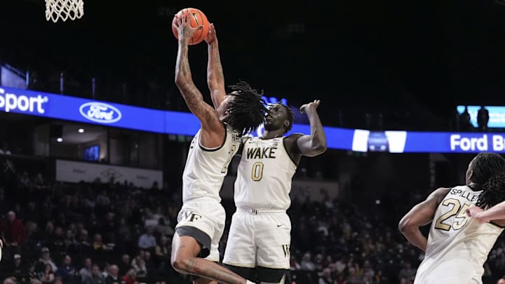Dec 14, 2025; Winston-Salem, North Carolina, USA; Wake Forest Demon Deacons guard Juke Harris (2) grabs the rebound in front of forward Omaha Biliew (0) against the Queens University Royals during the second half at Lawrence Joel Veterans Memorial Coliseum. Mandatory Credit: Jim Dedmon-Imagn Images