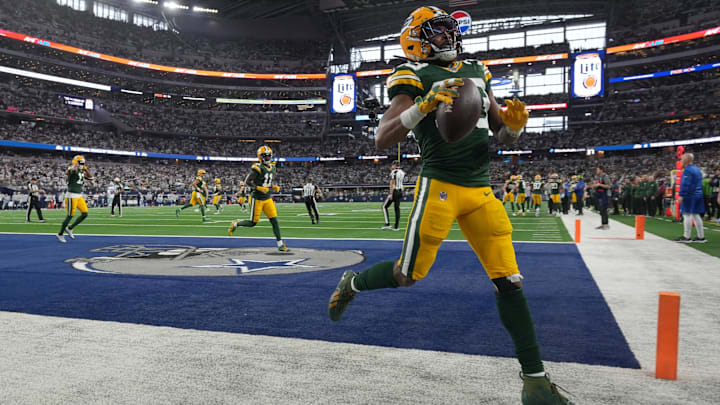 Green Bay Packers running back Aaron Jones tosses the ball in the stands after scoring a touchdown during the first quarter of the wild card playoff game against the Dallas Cowboys