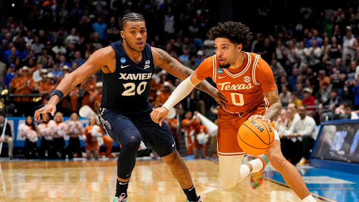 Texas Longhorns guard Jordan Pope (0) drives against Xavier Musketeers guard Dayvion McKnight (20) in the first half of the NCAA Tournament First Four game between the Xavier Musketeers and the Texas Longhorns at University of Dayton Arena in Dayton, Ohio, on Wednesday, March 19, 2025. Xavier advances with an 86-80 win over Texas, moving on to play Illinois in the first round.